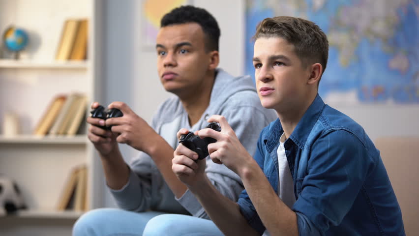 African-American and European teenagers playing video games, gaming addiction | Shutterstock HD Video #1024828472