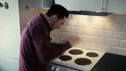 Stupid man places hand on hot stove. Painfully burns himself.