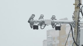 three security cameras on a lamppost.