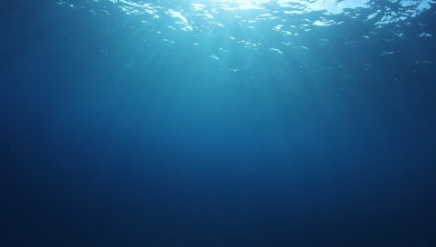 Underwater blue background in ocean with sunbeams Stock Photo