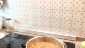 Cooking Malay dish Kuah Laksa Johor or rice noodle curry gravy in the kitchen. Selective focus.Tilt down footage.