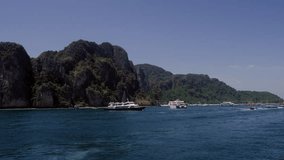 Sailing and motor boats moving near the koh phi phi island pier in Thailand. LIfestyle travel video in 4K
