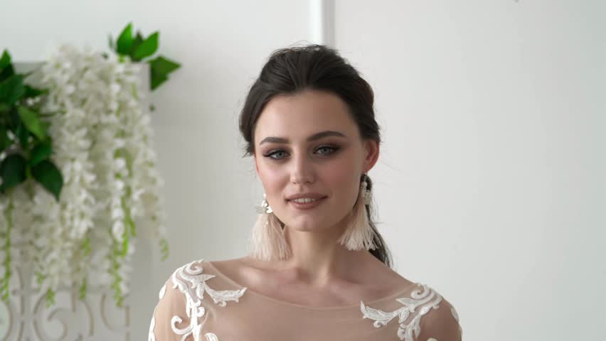 Portrait of a bride in wedding dress. Elegant brunette bride with flowers | Shutterstock HD Video #1024853930