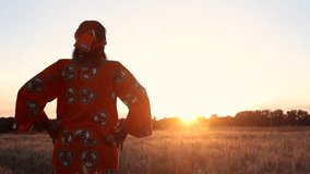 HD Video clip of African woman farmer in traditional local clothing standing looking into the sun in a farm field of crops in Africa at sunset or sunrise