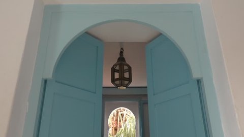 Double-leaf or double doors opening slowly revealing part of Arabic style house interior