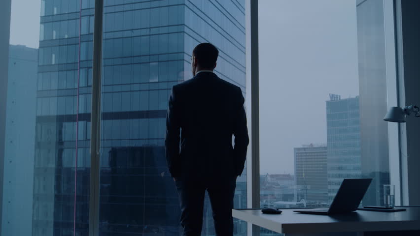 Back View of the Thoughtful Businessman wearing a Suit Standing in His Office, Contemplating Next Big Business Deal, Looking out of the Window. Business District Panoramic Window View | Shutterstock HD Video #1024870199