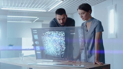 Futuristic Concept: Male and Female Computer Engineers Talk While Working on the Holographic Display Computer. Screen Shows Interactive Neural Network, Artificial Intelligence Project, User Interface