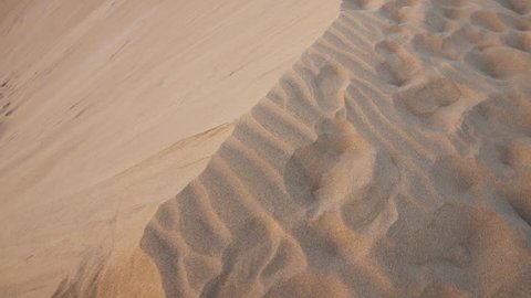 foot prints on the edge of a sand dune in desert landscape 
