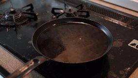 Frying chicken egg on a kitchen stove. Selective focus under low light. 