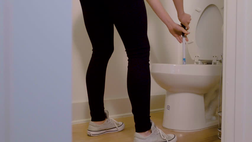Ground view of a woman trying hard to unblock a stinky toilet with a plunger, 23.98 fps. Royalty-Free Stock Footage #1024915037