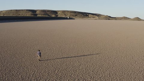 Climate change.  Climate emergency. Aerial view of a devastated farmer walking across a dry dam due to drought from climate change and global warming