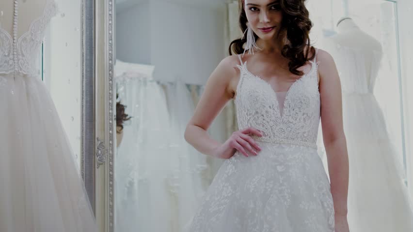 Beautifu bride choosing wedding dress in a wedding salon