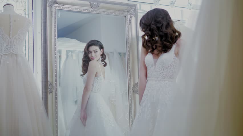 Beautifu bride choosing wedding dress in a wedding salon