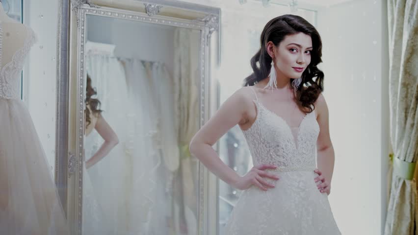 Beautifu bride choosing wedding dress in a wedding salon