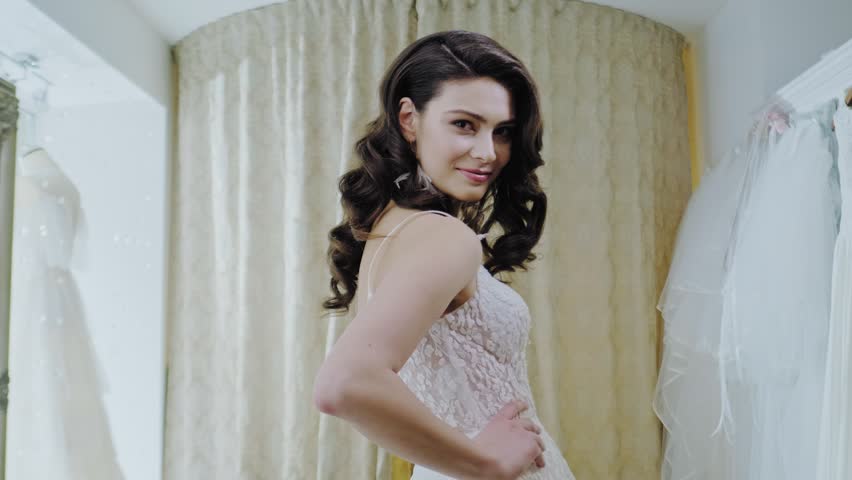 Beautifu bride choosing wedding dress in a wedding salon