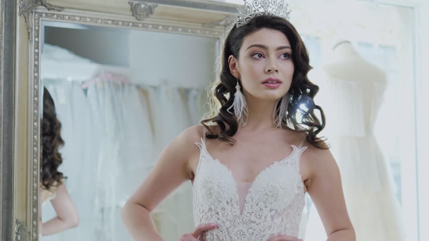 Beautifu bride choosing wedding dress in a wedding salon