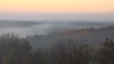 top view of the deciduous autumn forest at dusk and the sky in the haze. Autumn season, 4k.