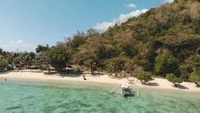 Aerial footage of Dimanglet Island next to Coron in Philippines. Stunning view of turquoise water, white sand beach, boats, palm trees, tropical paradise / 4K Drone Video