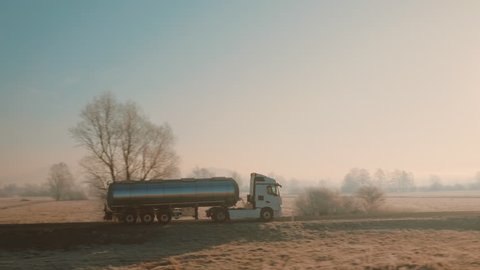 Tank truck on the countryside road. Aerial side tracking shot on a beautiful winter morning.