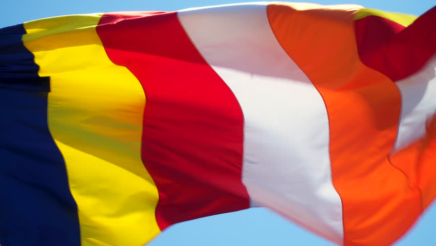 Buddhist flag against blue sky. Slow motion. Colored flag waving in the wind. six colours of the aura of the Buddha