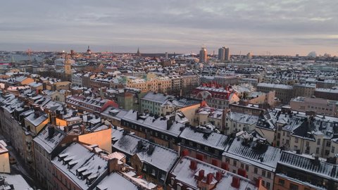 Stockholm city aerial view of buildings in Södermalm. Drone shot flying over snowy rooftops, winter in Stockholm, Sweden