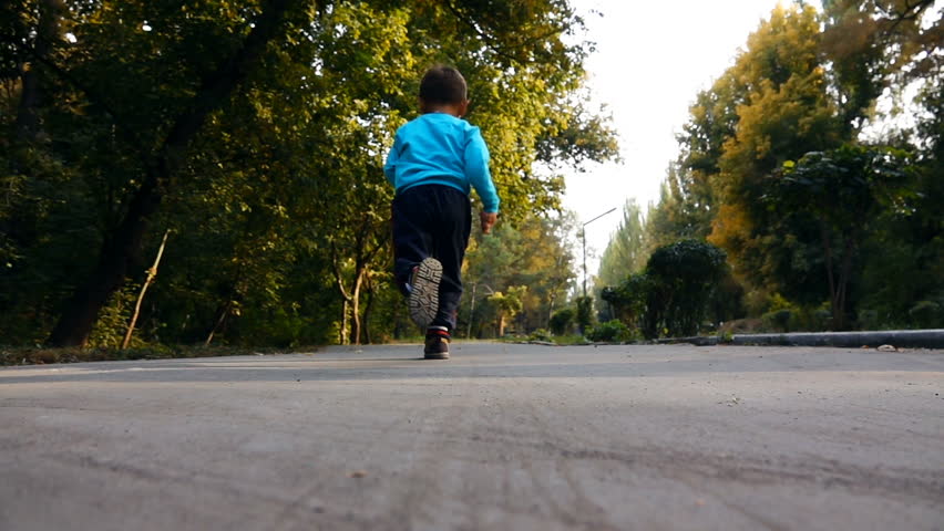 Little Boy Runs on the Road in the Botanical Park