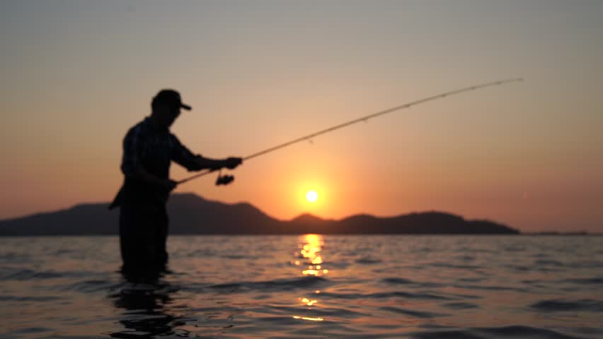 Asian young men Fishing in the reservoir At sunset .
