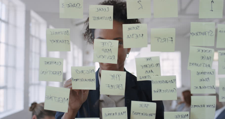 mixed race business woman using sticky notes brainstorming ideas problem solving with creative mind map planning strategy in office working on solution Royalty-Free Stock Footage #1024940507