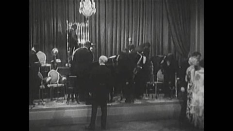 CIRCA 1920s - An orchestra plays in a formal ballroom in 1930.