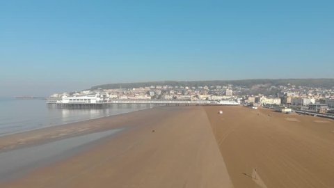 Drone shot of sandy beach & pier in ocean side town