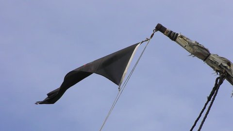 Pirate flag on a pleasure boat evolving against blue sky