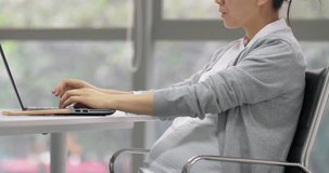  Asian adult woman typing on computer and communicating with the clients Asian working female in pregnancy 4k clip