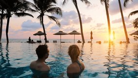 Couple at beach vacation holidays resort relaxing in swimming pool with scenic tropical landscape at sunset, island  destination, people talking together