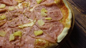 4K video close-up of a pizza hawaii with ham, cheese and pineapple