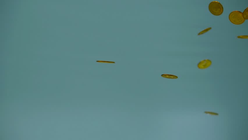 gold coins slowly floating under water