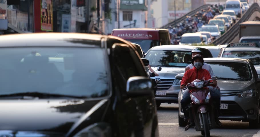 Ho Chi Minh city, Vietnam 03 2019: Slow moving traffic with a lots of motorcycles, motorbike, bus, car, and people walking transport on the road. Urban infrastructure problem, traffic congestion asia | Shutterstock HD Video #1024992890