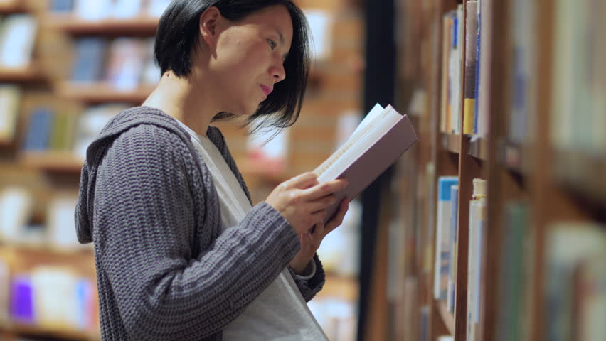Side view of one pregnant Asian woman reading book in the library. pregnant female urban lifestyle 4k clip. concept of education   | Shutterstock HD Video #1024995893