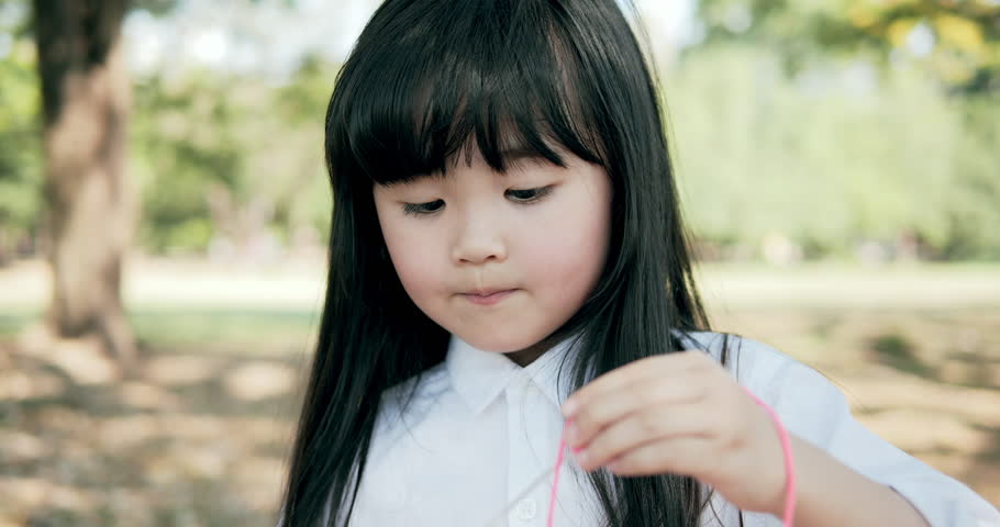 Young beautiful girl are blowing bubble at park. 4k Resolution. Slow motion shot.