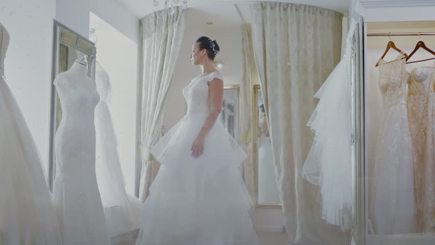 Beautifu bride choosing wedding dress in a wedding salon