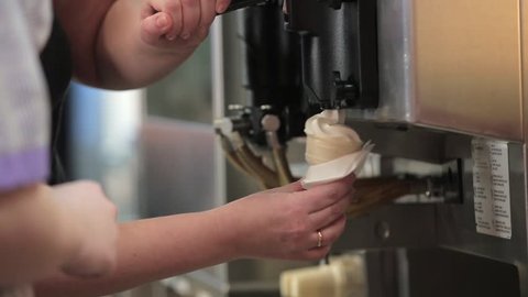 Minsk, Belarus, February 16, 2016: A worker fills a waffle cup with ice cream in a McDonalds restaurant.