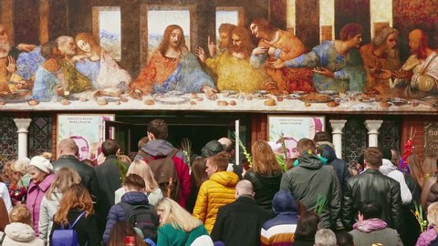 Minsk, Belarus - Apr 9, 2017: Crowd of parishioners go up the stairs of the Catholic church under the reproduction of Leonardo da Vinci's "Last Supper" on Palm Sunday.