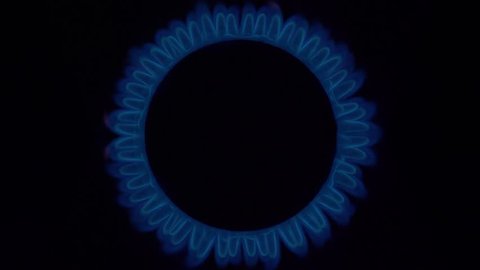 cook sets fire to the stove burner turning on. Stove top burner igniting into a blue cooking flame isolated on black background. Natural gas inflammation, close up. audio bursting flame sound