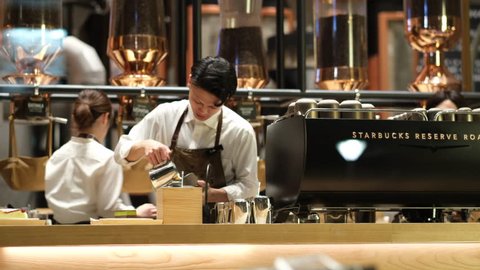 TOKYO, JAPAN - MARCH 2ND, 2019. Starbucks Reserve Roastery customers and baristas at night. The newly opened establishment is the 5th of such outlet and the largest in the world.