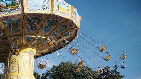 Paris, France. Summer, 2018. Swing chair roller coaster ride with riders having fun on a summer day.