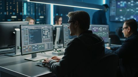 Team of IT Programers Working on Desktop Computers in Data Center Control Room. Young Professionals Writing on Sophisticated Programming Code Language