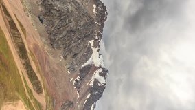 Vertical video. Clouds over snowy peaks. Talgar Pass, Chimbulak. Almaty. Kazakhstan