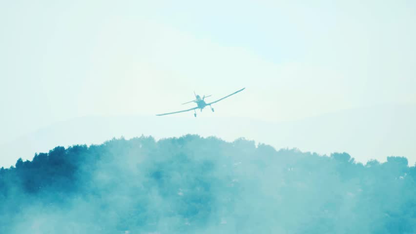 Plane drops water on forest fire slow motion