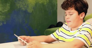 Portrait of a preteen boy with smartphone sitting at home. Kid watching to screen, reading, typing, playing games. Technology, internet communication and people concept, Smartphone addiction