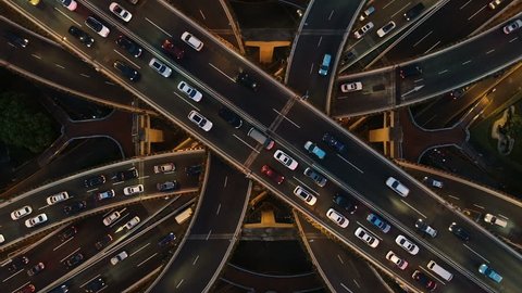 Rising drone shot reveals spectacular elevated highway and convergence of roads, bridges, viaducts in Shanghai at night, transportation and infrastructure development in urban China