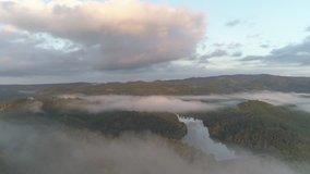 Aerial view of a drone flying over beautiful low level clouds and a lake in Chiang Rai Northern Thailand